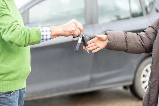 Scène d'intérieur professionnel avec deux personnes effectuant une remise de clés automobile